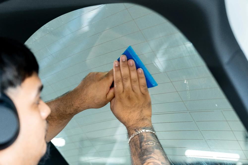 Ceramic window tint squeegeed onto a rear windshield